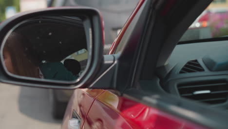 Impatient-woman-looks-in-car-mirror-to-check-road-condition