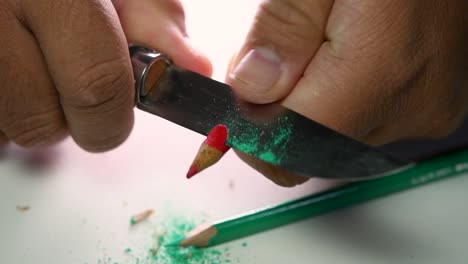 Footage-of-hands-slowly-sharpening-a-pencil-and-some-coloured-pencils-with-a-sharp-knife