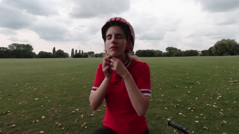 Una-Joven-Ciclista-Caucásica-Se-Pone-Un-Casco-Rojo