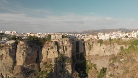 Vor-Den-Klippen-Im-Süden-Spaniens-Liegt-Die-Mittelalterliche-Stadt-Ronda-Mit-Ihren-Spektakulären-Brücken-Und-Bögen-Mit-Blick-Auf-Die-Weiten-Ebenen-Andalusiens