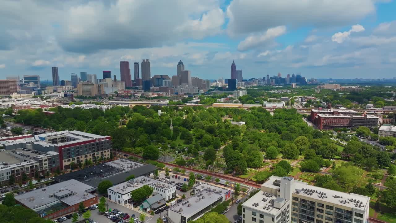 Shopping Center and apartments in suburb of Atlanta city. Skyline with skyscrapers downtown in distance. Aerial wide shot. Sunny day with green trees on summer day in USA