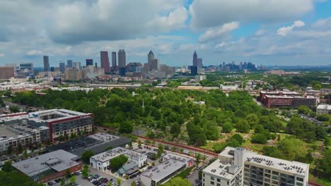shopping center and apartments in suburb of atlanta city. skyline with skyscrapers downtown in distance. aerial wide shot. sunny day with green trees on summer day in usa