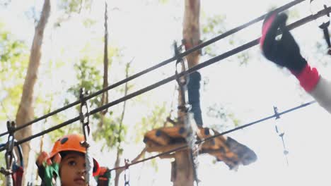 Man-assisting-children-to-cross-zip-line-in-the-forest-4K-4k