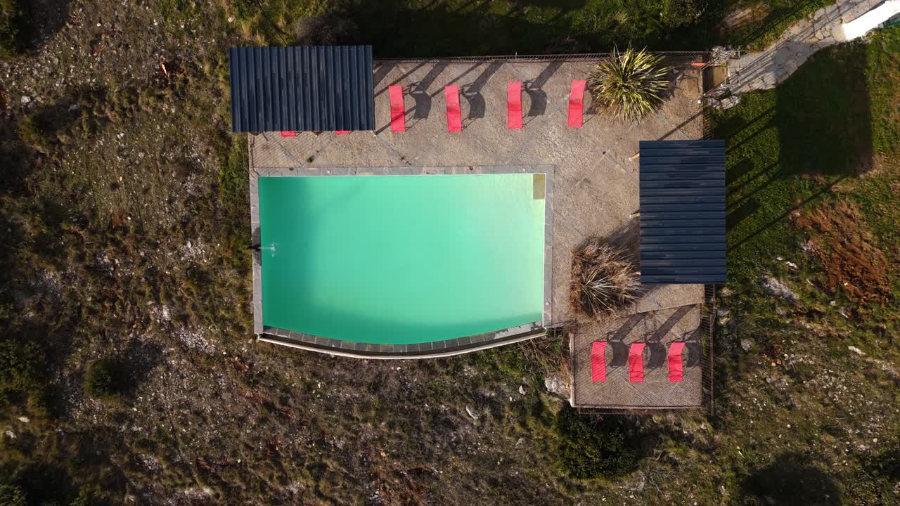 드론 비디오는 고립되고 조용한 수영장 풍경의 새의 눈으로 올라갑니다.