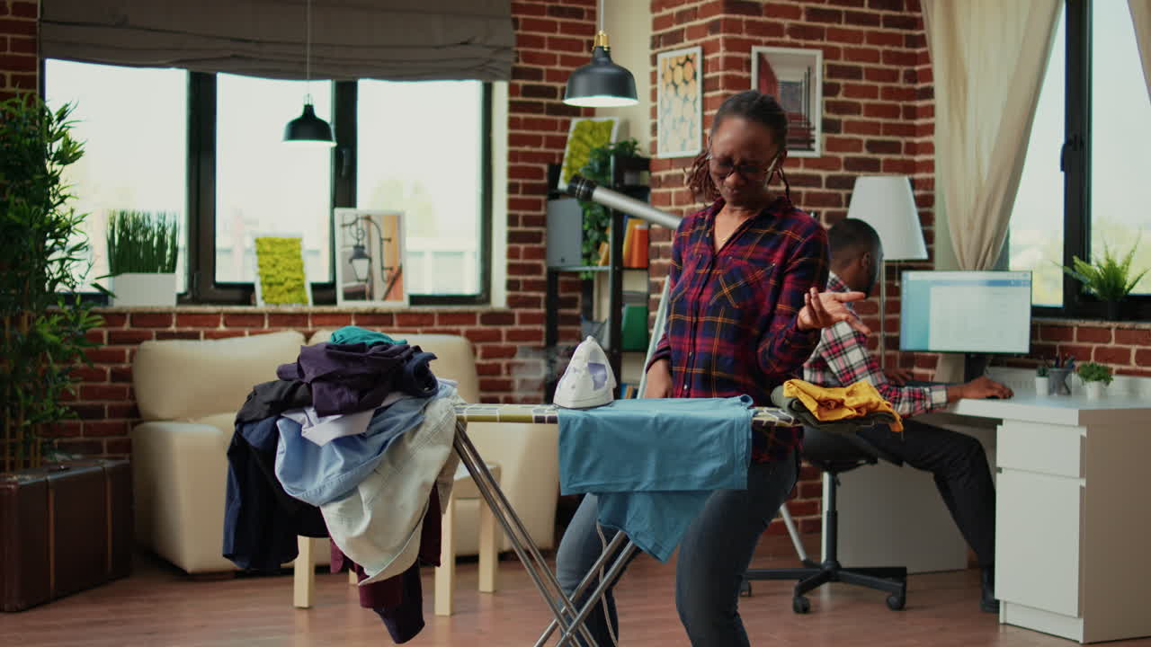 Young girlfriend enjoying doing ironing work at home