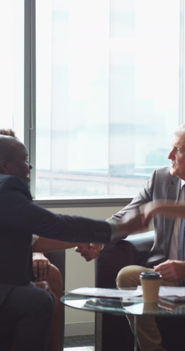 Business Professionals Shaking Hands During a Meeting in a Modern Office