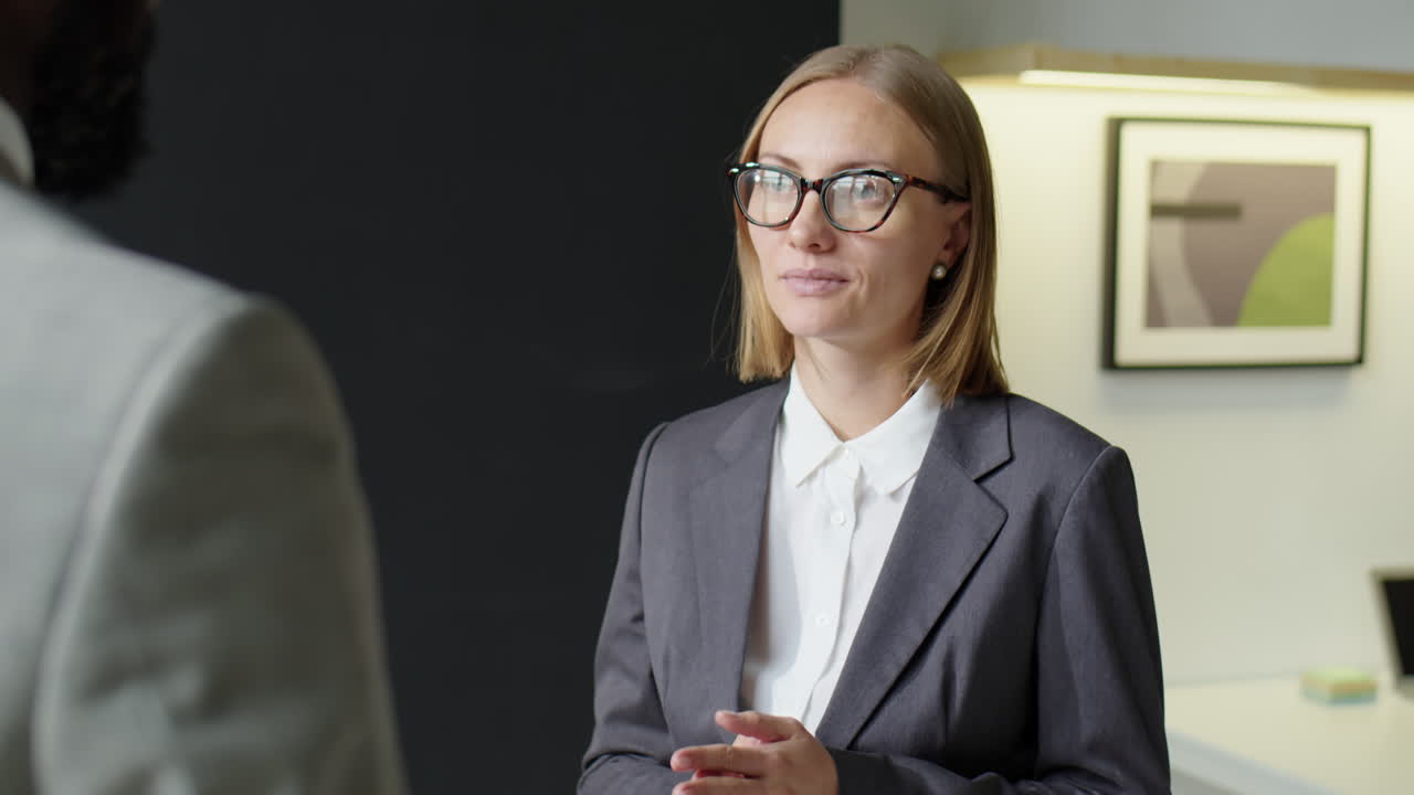 Businesswoman Talking and Giving Handshake to Colleague