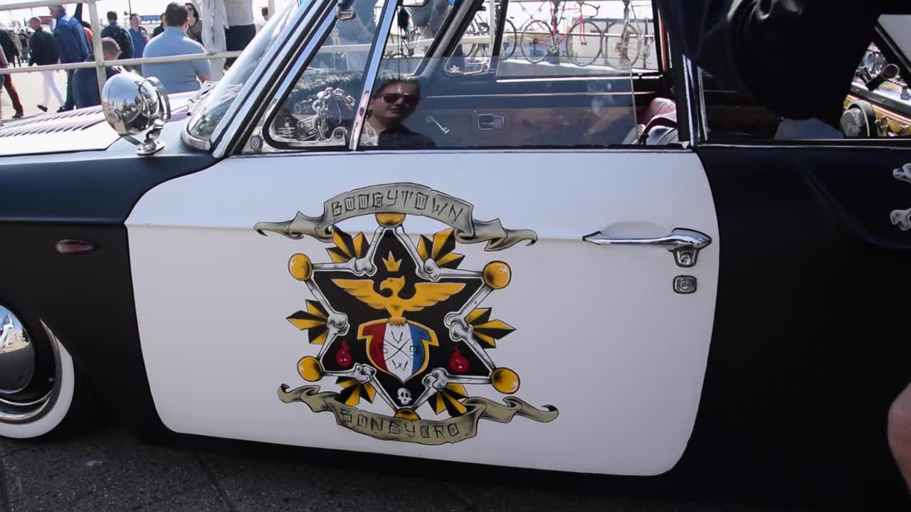 Man with camera photographing a vintage sheriff car on a car show