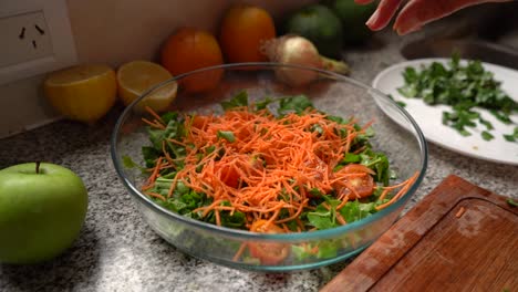zanahorias ralladas se vierten en ensalada de rúcula verde con tomates cherry