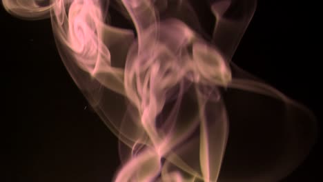 humo de chocolate que se eleva giros graciosos hacia arriba. humo de colores que sopla de abajo hacia arriba. primer plano, aislado en fondo negro