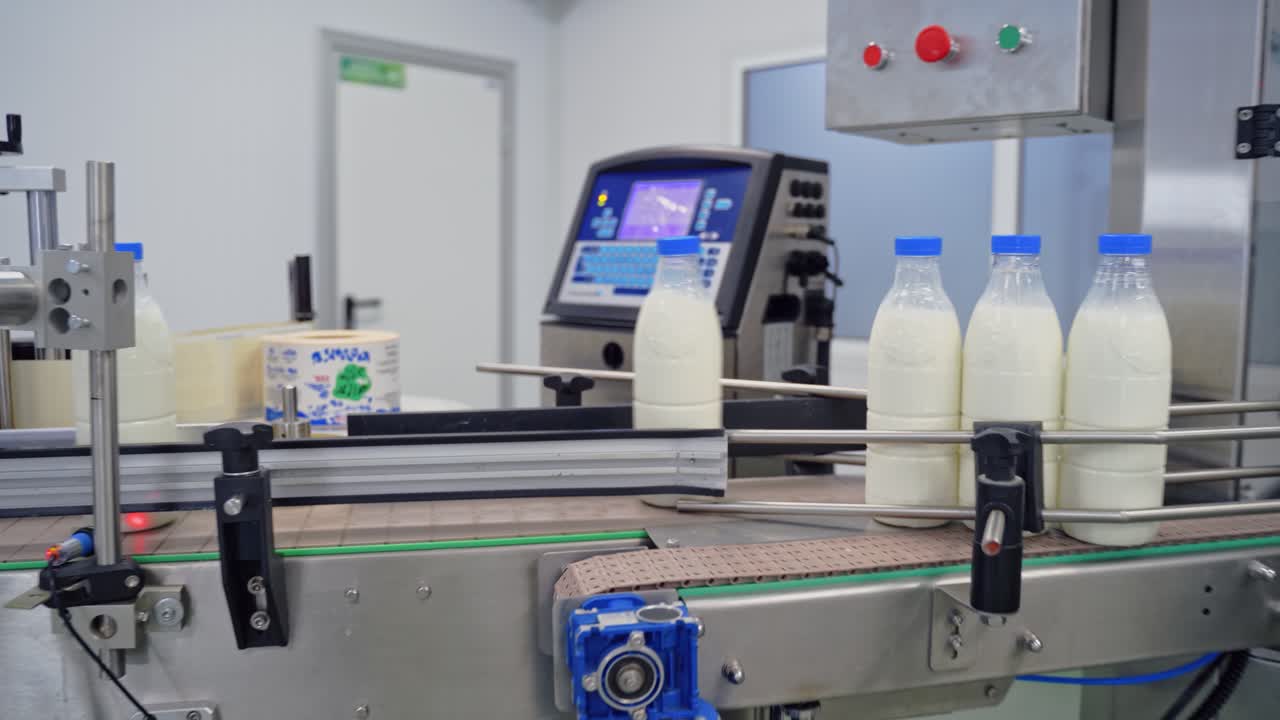 Automated company for packaging milk. Plastic bottles with fresh white milk on a conveyor belt. Modernized dairy plant.