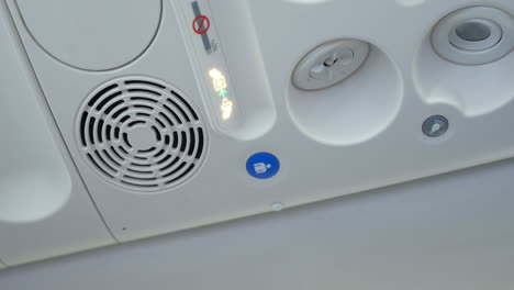 la mano del hombre apaga el sistema de ventilación o el aire acondicionado sobre el asiento a bordo del avión