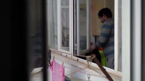 Young-man-hanging-up-the-laundry-at-home