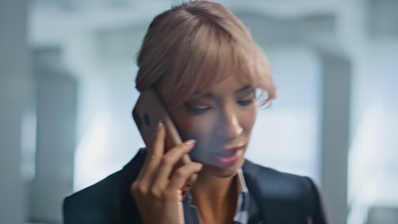 Portrait angry ceo calling smartphone at grey office. Boss yelling mobile phone