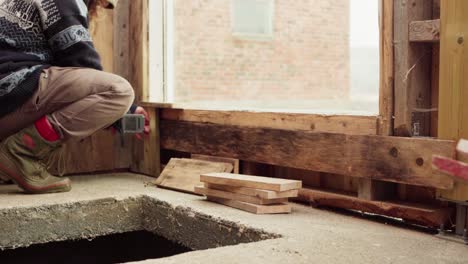 Hombre-Atornillando-Una-Tabla-De-Madera-Para-La-Pared-Del-Invernadero-Usando-Un-Perforador-Inalámbrico