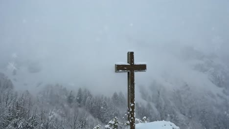 wooden cross on snowy mountaintop