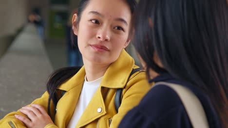 Close-Up-Of-Two-Smiling-Young-Female-Friends-Outside-Meeting-And-Talking-In-Urban-Setting-1