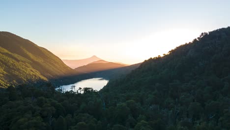 Dolly in and out hyperlapse of Tinquilco lake, forest mountains and Villarrica volcano at golden hour, Huerquehue National Park, Chile