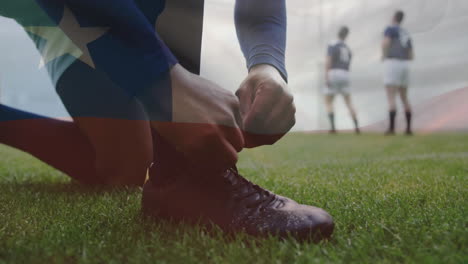 Animación-De-La-Bandera-De-Chile-Sobre-Un-Jugador-De-Rugby-Caucásico-Atando-Una-Bota-En-Un-Campo-De-Rugby.