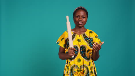 rebel tough woman threating to hit someone with a rolling pin as a weapon