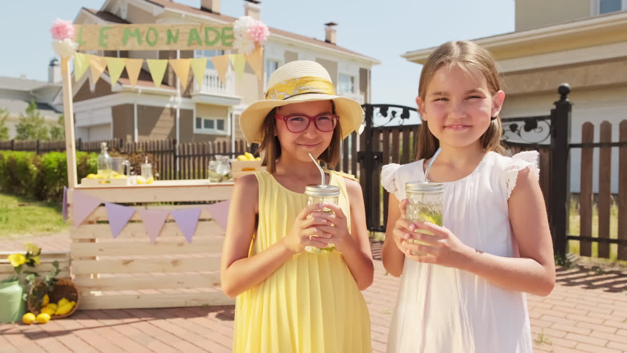 Pretty Little Girls Drinking Lemonade Outdoors