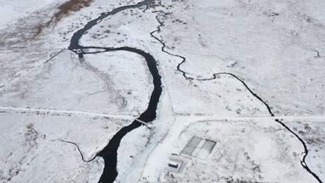 Tilting-drone-shot-of-the-snowy-Gress-river-with-Gress-beach-and-Point-in-the-background-on-the-Outer-Hebrides-of-Scotland