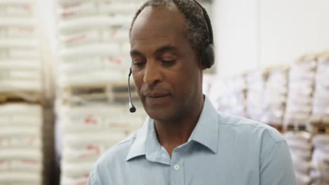 portrait of middle aged man in warehouse storeroom wearing a headset 4k