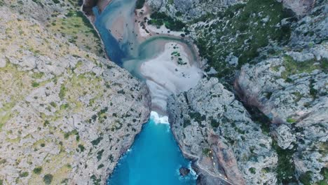 breathtaking 4k aerial top down view in 4k of the famous beach sa calobra in mallorca, spain - wide view serra de tramuntana - massive cliff landscape at the ocean - mediterranean sea balearic islands