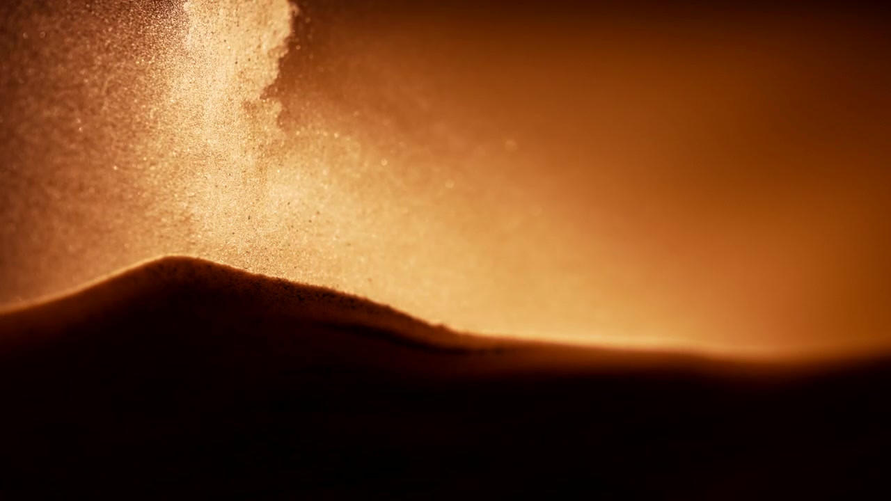 Partikler falder på sandbunken i slowmotion. Abstrakt makrobillede