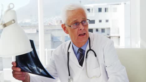 médico de sexo masculino examinando las radiografías