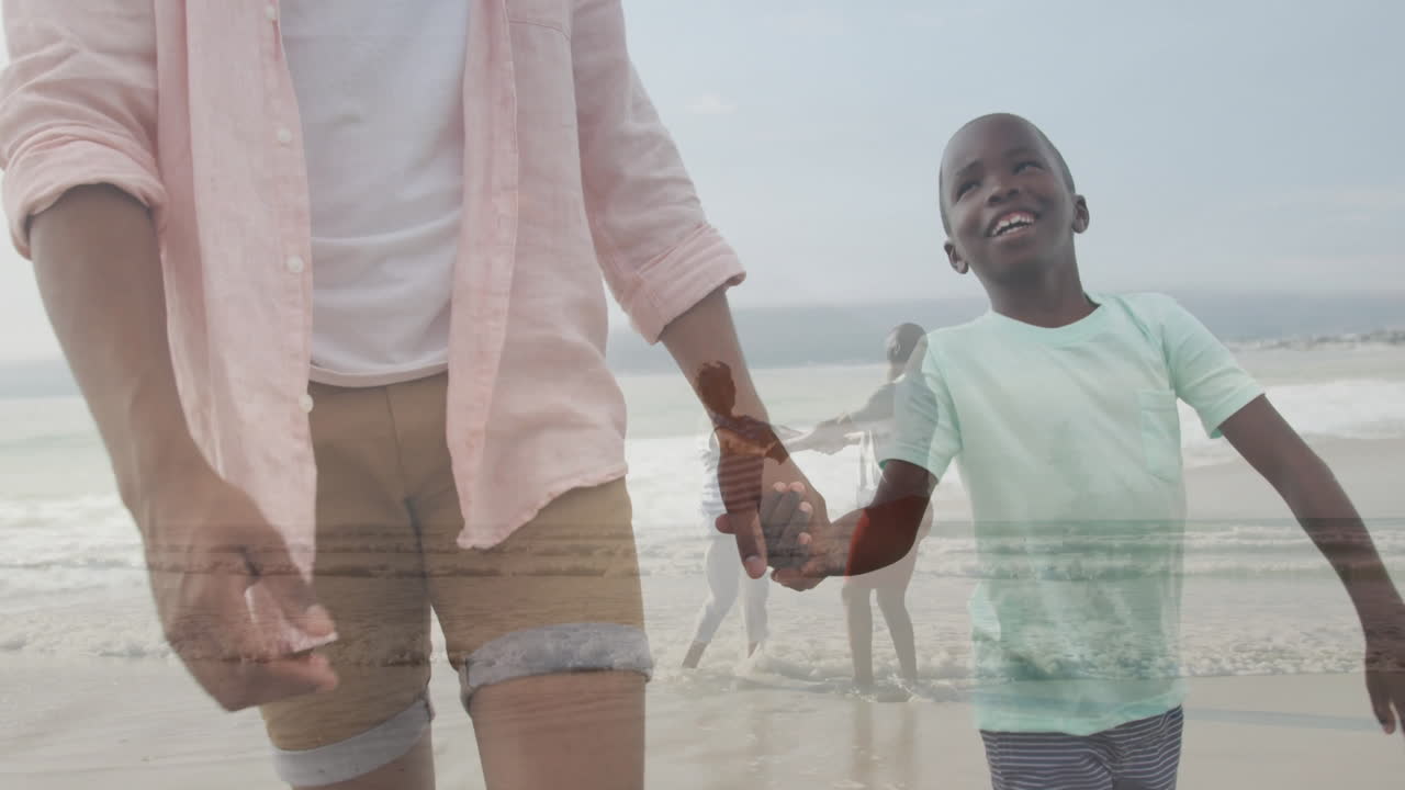Animation of child holding hands with adult, walking along beach with ocean waves
