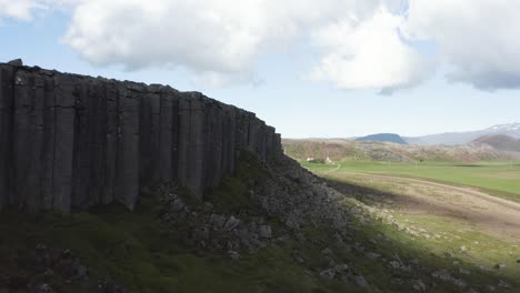 Flying-past-edge-of-Gerouberg-basalt-columns-solidified-by-sea,-aerial