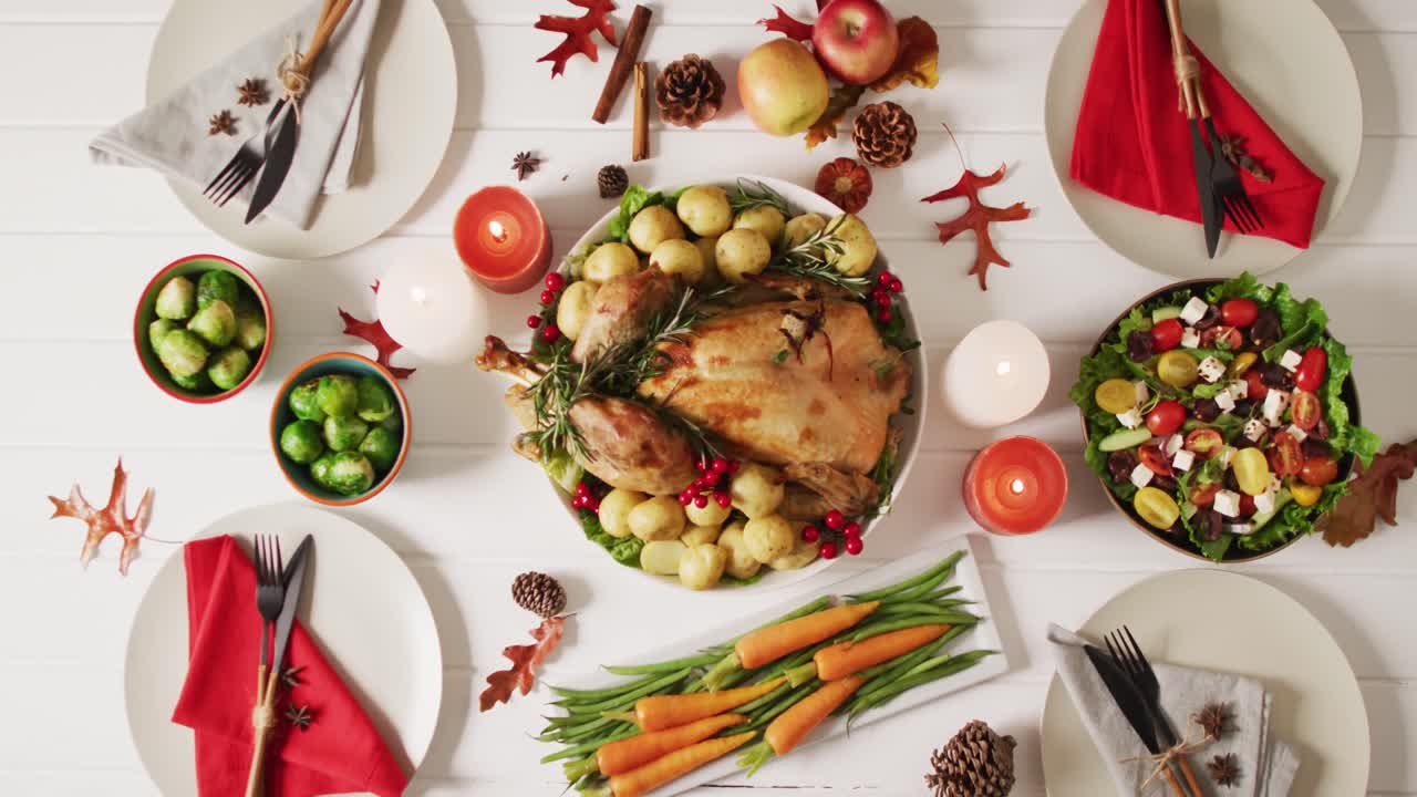 video de bandeja con pavo asado, platos diversos y decoración de otoño en superficie blanca