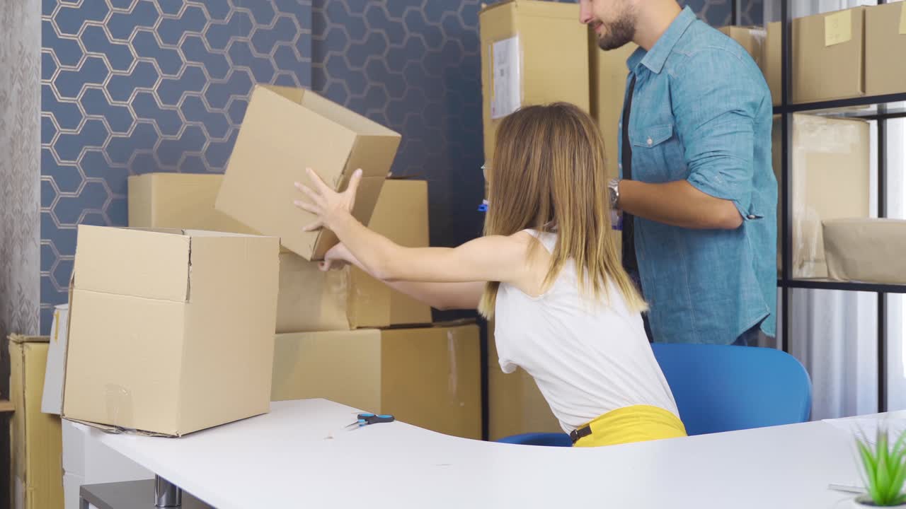 mujer de negocios emprendedora y hombre de negocios empaquetando paquetes de pedidos en la oficina.