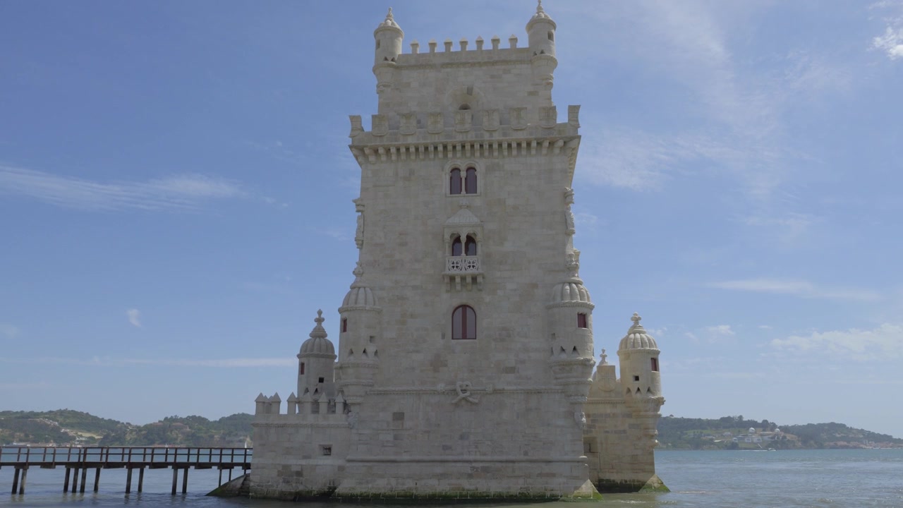 Torre de Belém en Lisboa, Portugal, con torretas manuelinas, almenas y el río Tajo detrás.