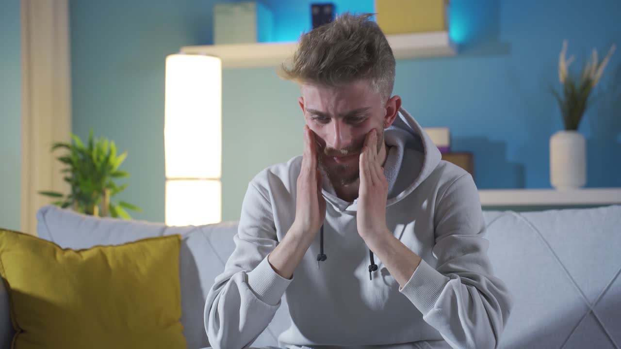 Nervous and depressed young man thoughtful at home.