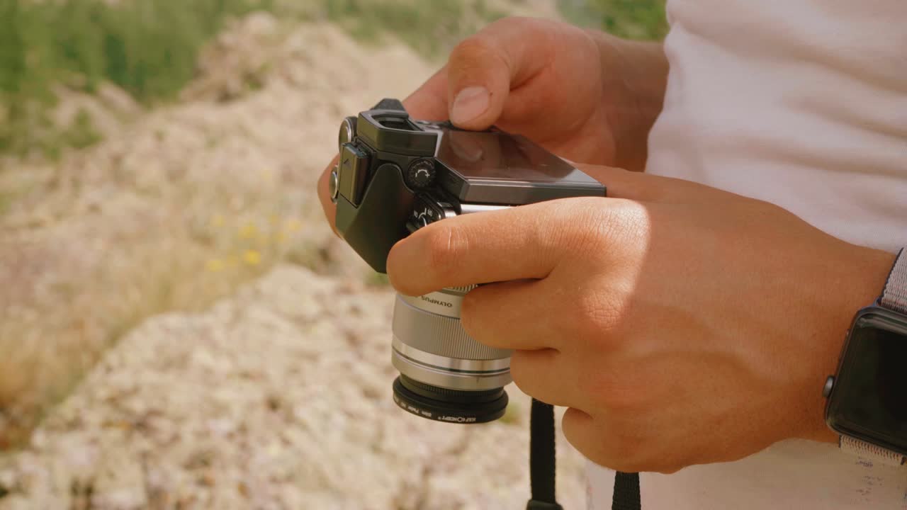 Person adjusting camera settings outdoors