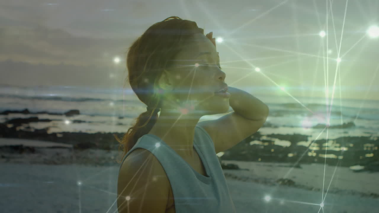 On beach, woman standing with animated network connections overlay in background