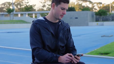 atleta discapacitado que usa teléfono móvil en un recinto deportivo 4k