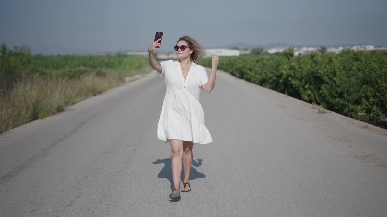 Donna che si scatta un selfie su una strada.