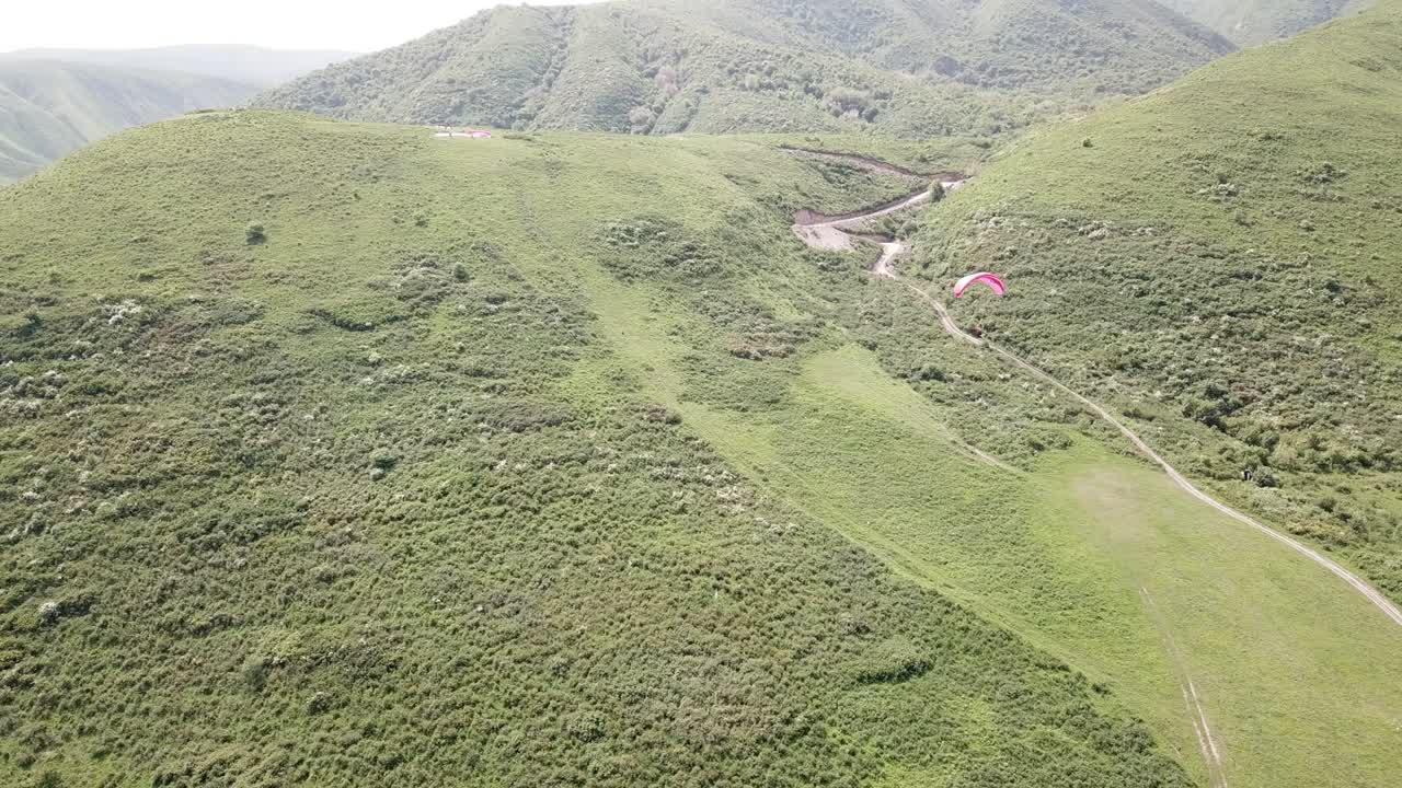 parapenteo en las montañas, campos verdes, colinas