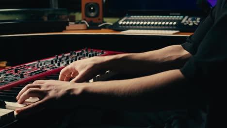 close up of keyboard player hands playing rock music with keyboard at the concert in studio, rehearsal room, macro play on synthesizer.