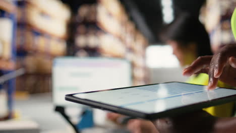 vertical video close up of african american person checking tracking info for parcels on tablet