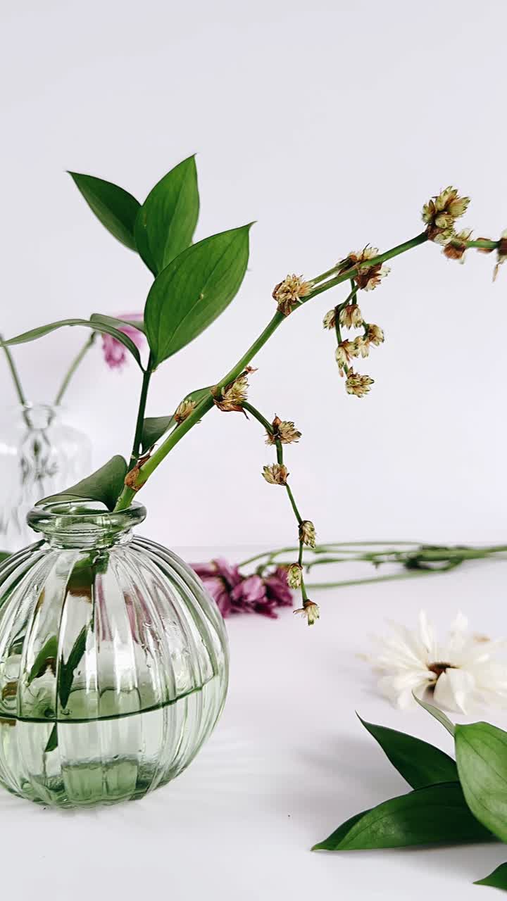 Élégante composition florale dans un vase en verre vert