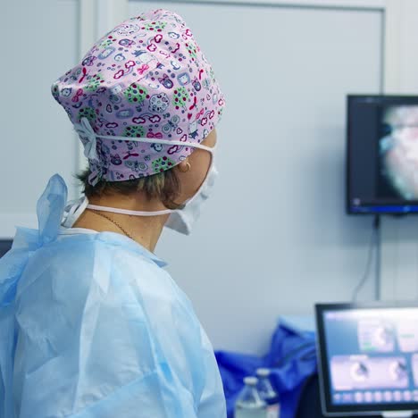 surgeon is looking at screen at the operating room. doctor using microscope during eye surgery process. treatment of cataract and diopter correction
