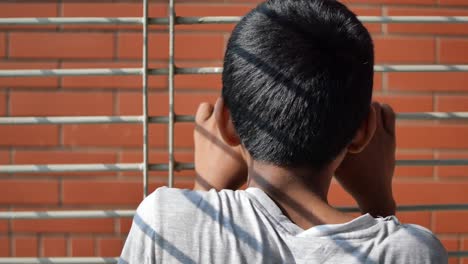 un adolescente triste mirando por la ventana