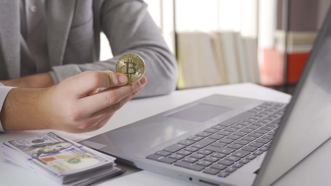 비트코인 투자. 주식시장을 따르는 사람이 비트코인과 미국 달러를 테이블에 놓고 있습니다.