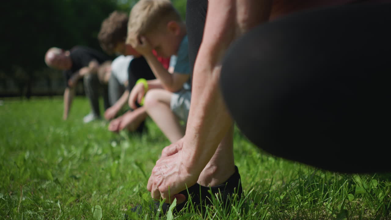 잔디에 무을 고 있는 가족의 클로즈업, 각 구성원이 조화롭게 신발를 고 있다.