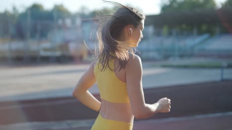 woman jogging on outdoor track in sportswear at athletic field