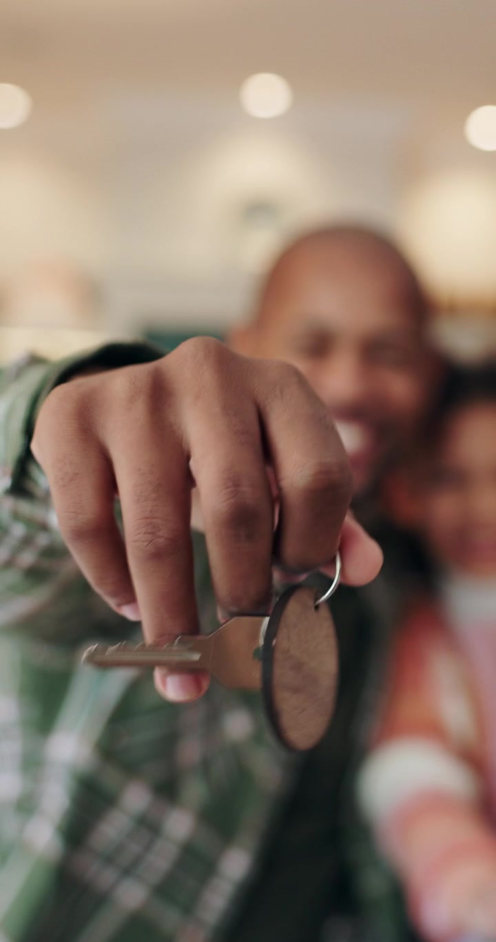 Padre felice che tiene in mano le chiavi della nuova casa con la figlia
